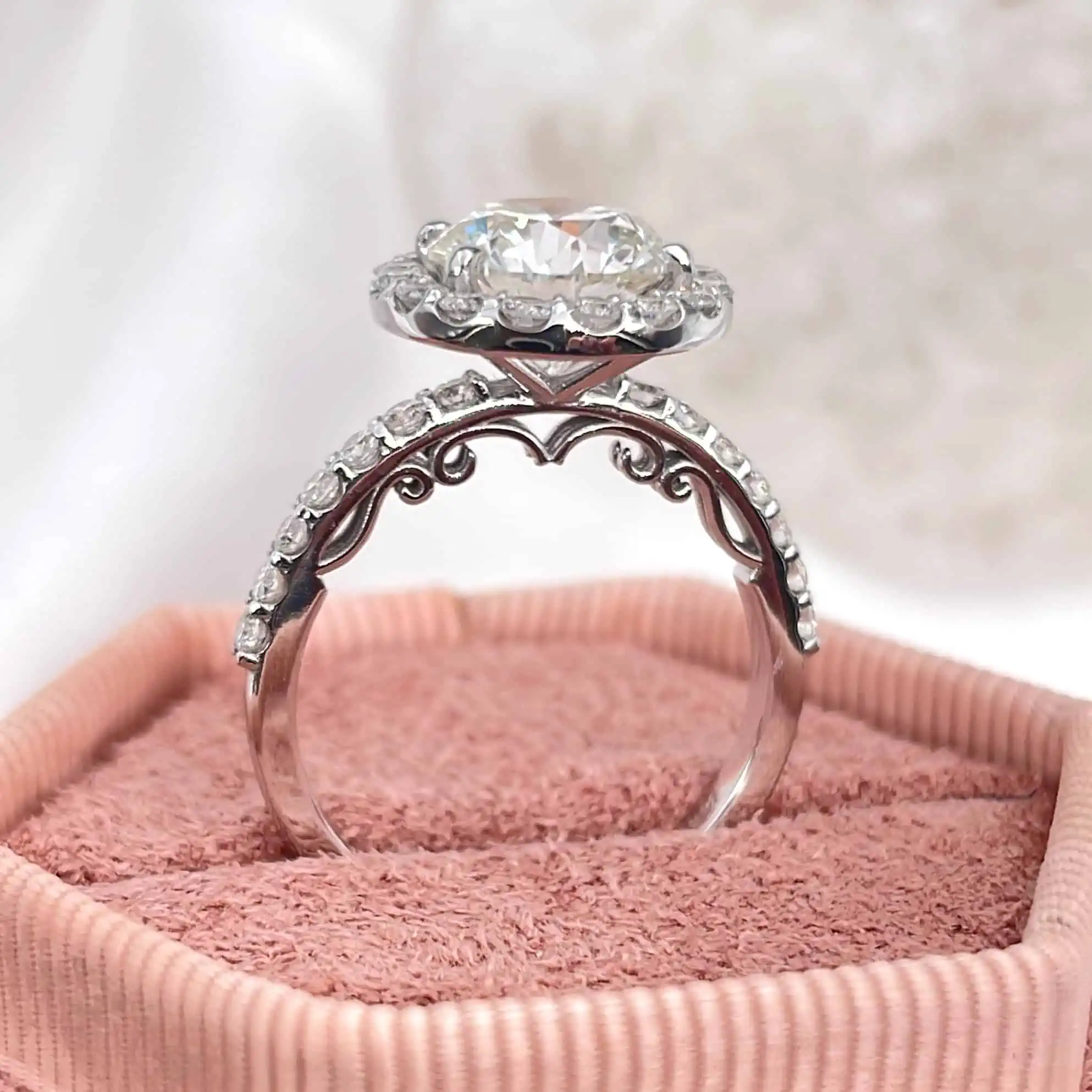 Unique Round Halo Lab Diamond Engagement Ring placed on a pink box