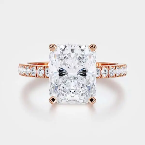 A Rose Gold Radiant Cut Engagement Ring with Hidden Halo and Pavéd Band on white background