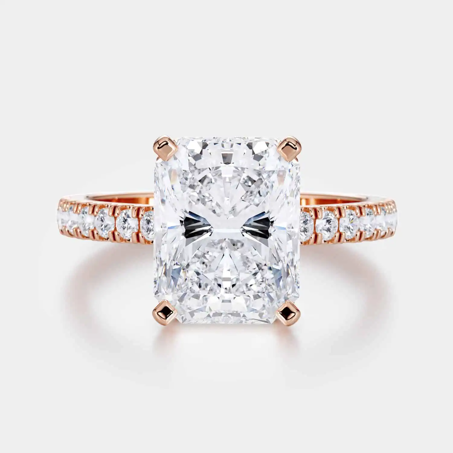 A Rose Gold Radiant Cut Engagement Ring with Hidden Halo and Pavéd Band on white background