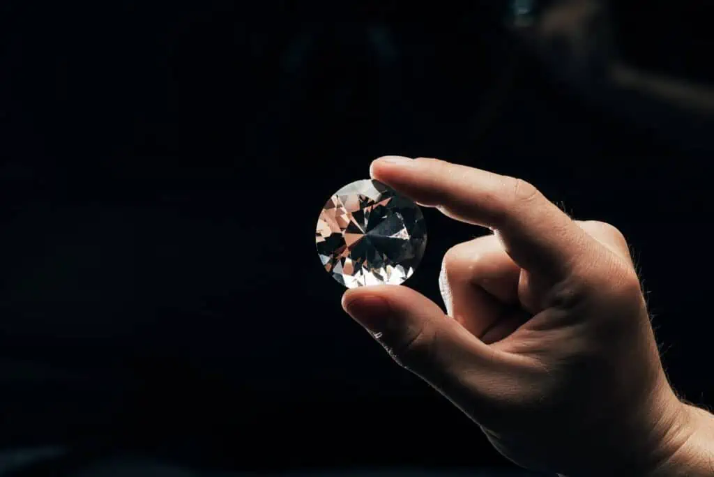 Hand holding a diamond to check its diamond clarity