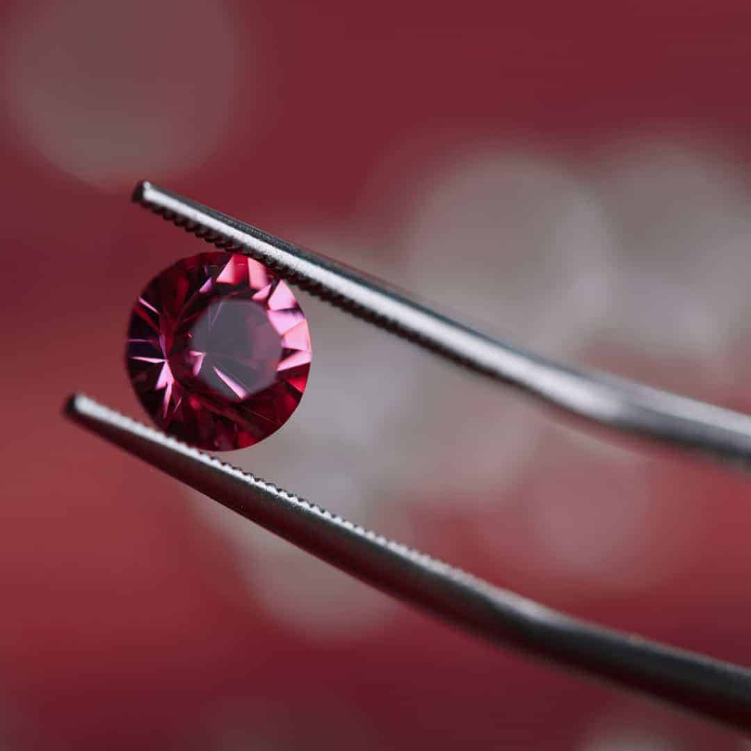 Ariel Jewelry | How Much Is a Diamond Really Worth? Red diamond holding for diamond engagement ring evaluation